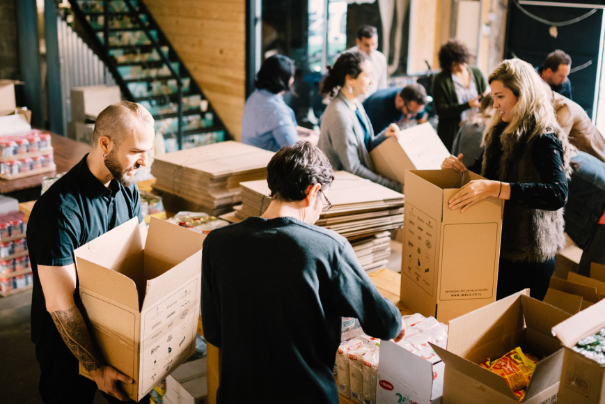 אנשים אורזים ארגזי סיוע Schusterman Family Philanthropies, ROI Community